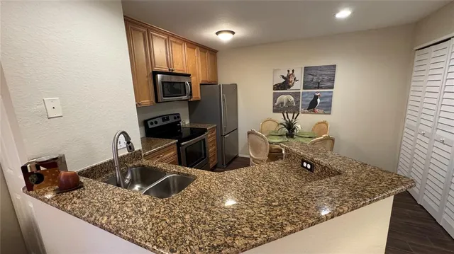 a kitchen with stainless steel appliances granite countertop a sink stove and refrigerator
