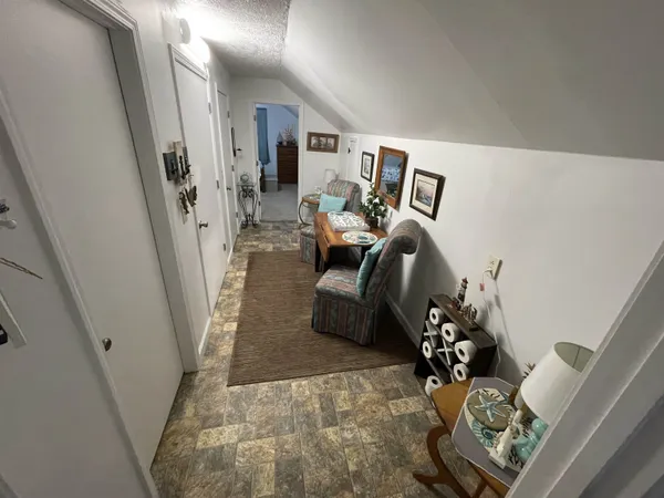 a living room with furniture a flat screen tv and kitchen view
