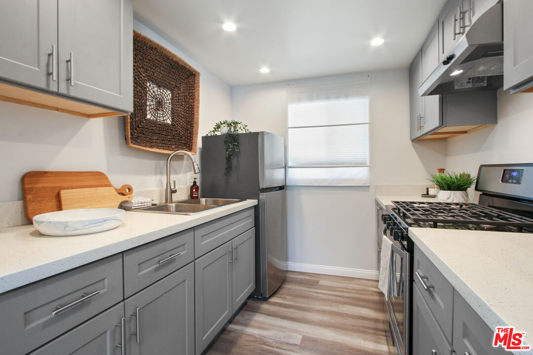 6438 Rhea Avenue Reseda, CA 91335 - Photo 6 of 9 a kitchen with stainless steel appliances granite countertop a refrigerator sink and stove