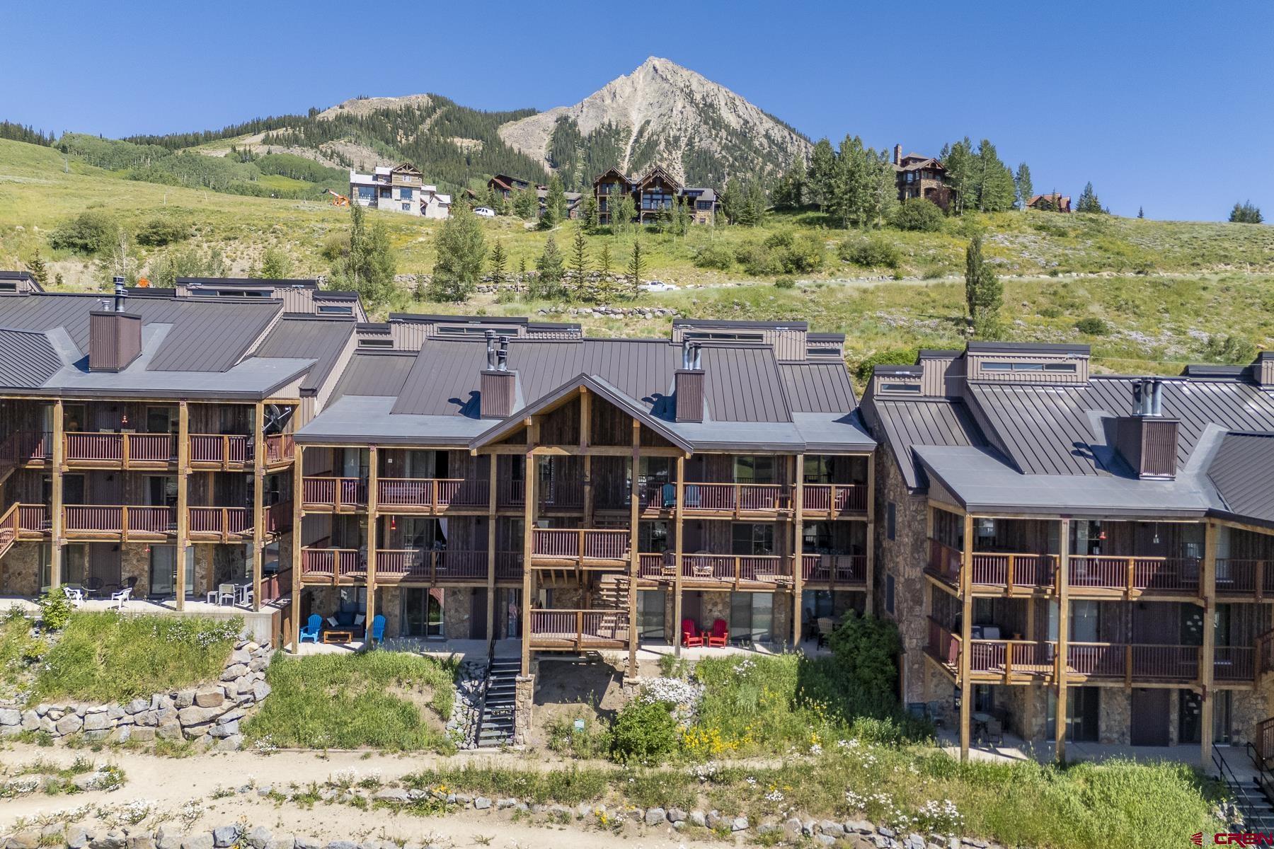 72 Hunter Hill Road, Unit I204 Crested Butte, CO 81225 - Photo 1 of 44 a view of a large building with a garden and plants