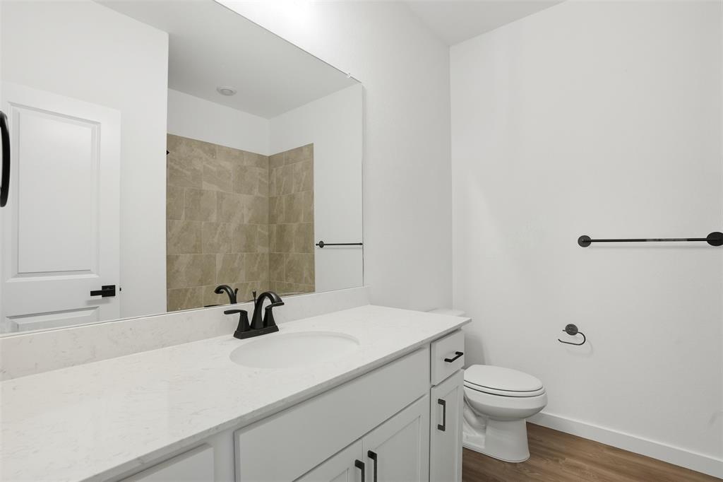 1606 Governors Boulevard Heath, TX 75126 - Photo 18 of 37 Full bathroom with vanity, dark wood finished floors, and a shower