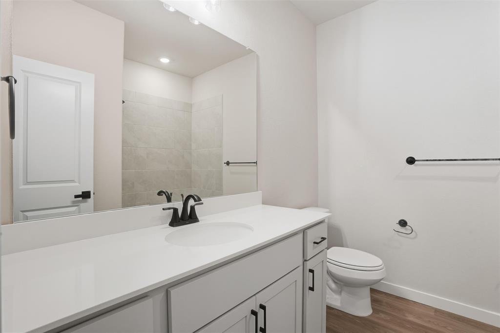 1606 Governors Boulevard Heath, TX 75126 - Photo 22 of 37 Bathroom with dark wood-style flooring, vanity, recessed lighting, and a shower