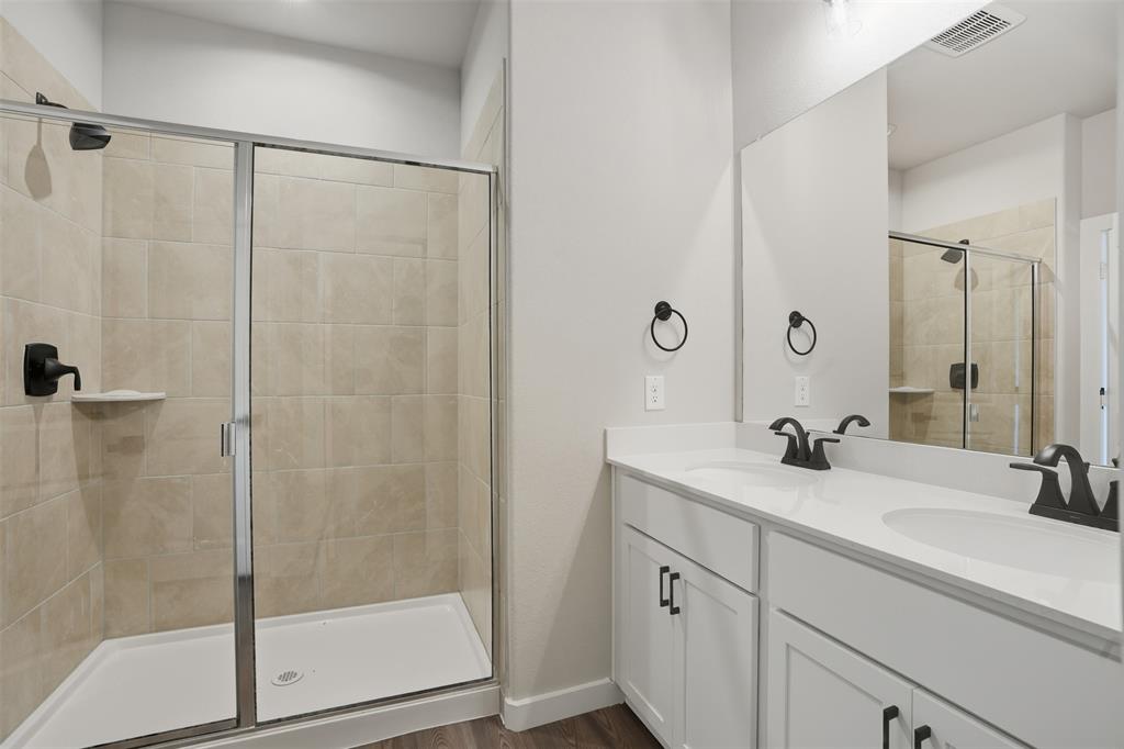 1606 Governors Boulevard Heath, TX 75126 - Photo 23 of 37 Bathroom with a shower stall, double vanity, and dark wood-style flooring