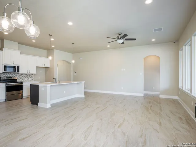 a view of kitchen with granite countertop cabinets stainless steel appliances and a fireplace