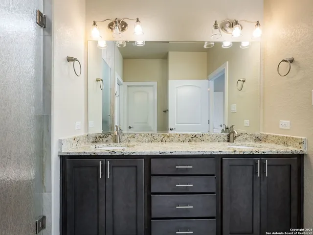 a bathroom with a granite countertop sink and a mirror