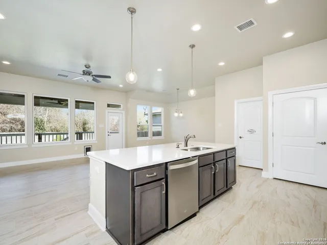 a large kitchen with kitchen island a sink stainless steel appliances and a large window