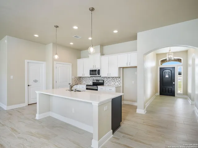 a kitchen with kitchen island a sink stainless steel appliances and cabinets