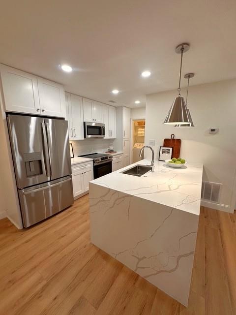 a kitchen with stainless steel appliances a refrigerator and a stove top oven