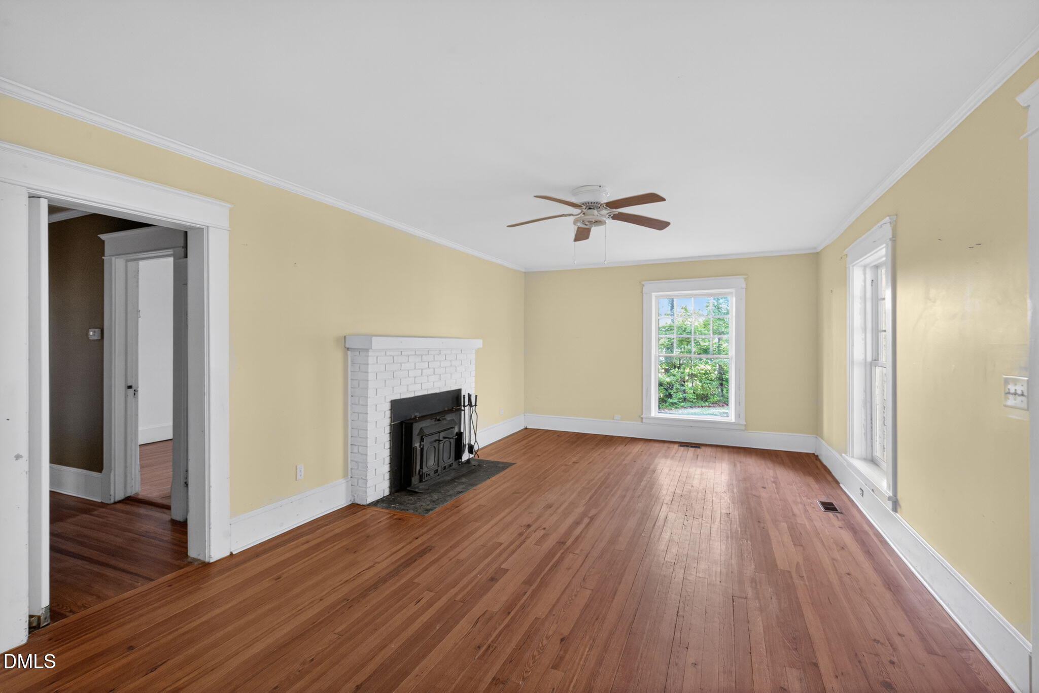 1714 Terry Road Durham, NC 27712 - Photo 6 of 39 an empty room with wooden floor fireplace and windows
