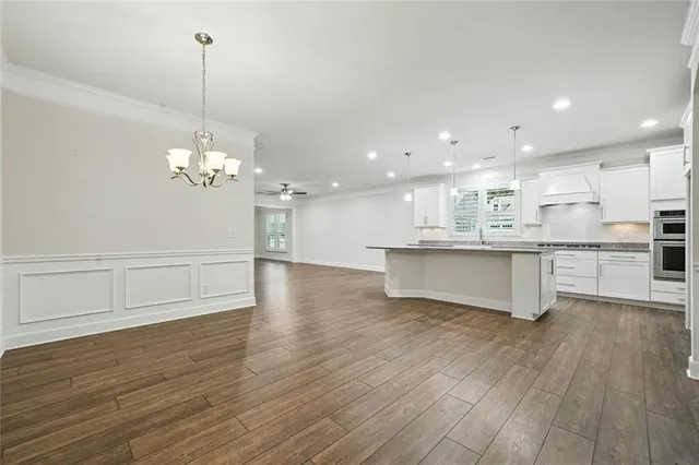 a view of an empty room with wooden floor fireplace and a window