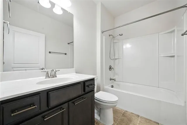 a spacious bedroom with a large bed and a chandelier