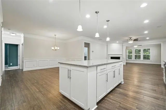 a large kitchen with cabinets wooden floor and stainless steel appliances