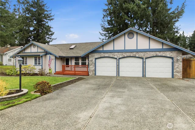 a view of a white house with large windows and a small yard