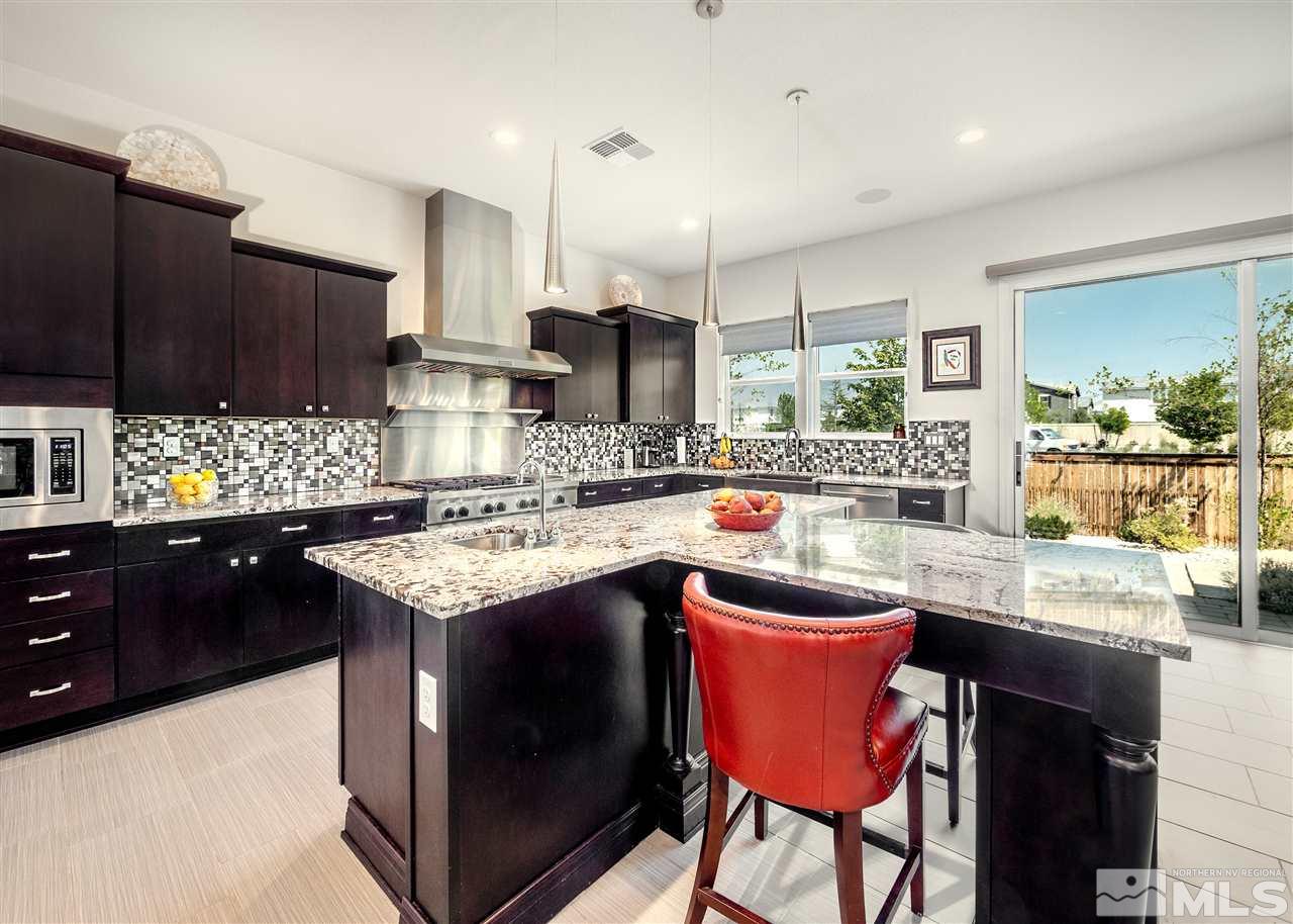 9715 Cardigan Bay Lane Reno, NV 89521 - Photo 5 of 31 a kitchen with granite countertop a sink stove and refrigerator