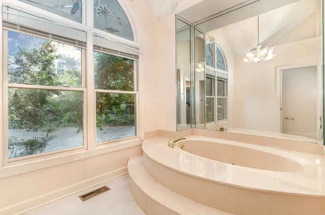 a bathroom with bathtub and window
