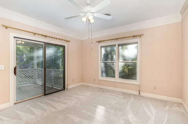 an empty room with fan and windows