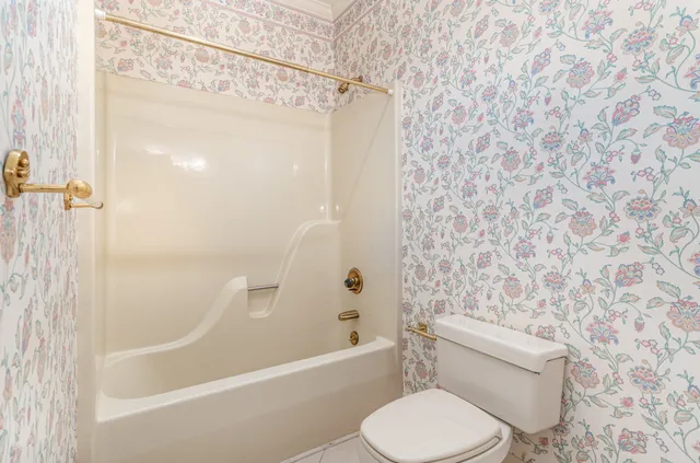 a bathroom with a toilet and a shower curtain