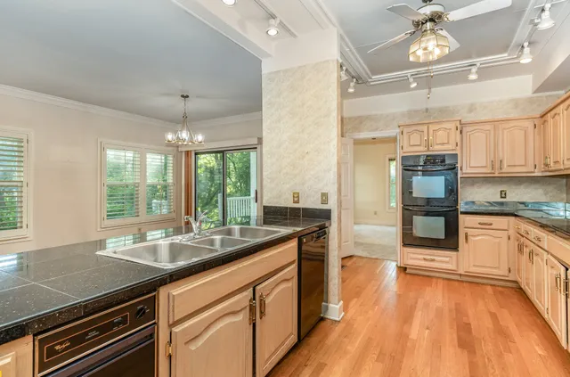 a kitchen with stainless steel appliances granite countertop a sink and wooden cabinets