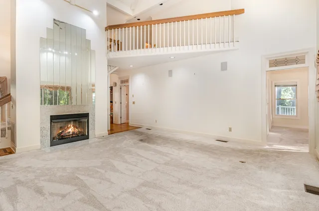a view of an empty room with fireplace and a window