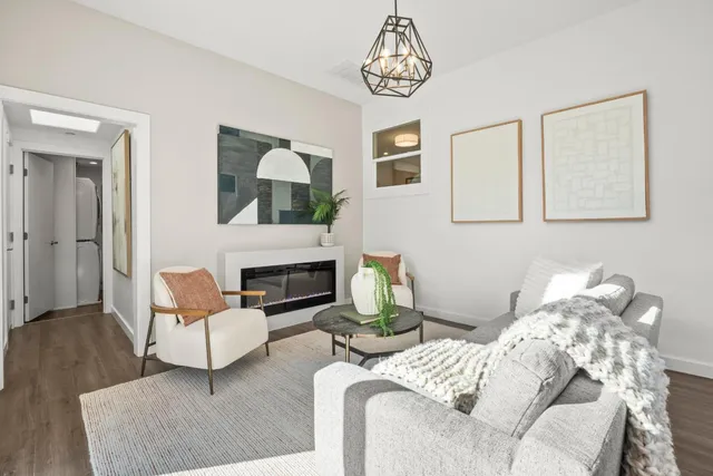 a living room with furniture chandelier and a fireplace