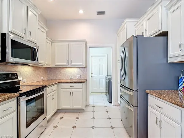 a kitchen with granite countertop white cabinets and a sink