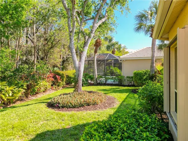 a view of a house with a yard and potted plants