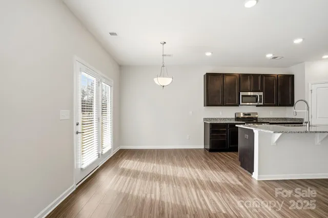 a view of kitchen with sink microwave and stove top oven