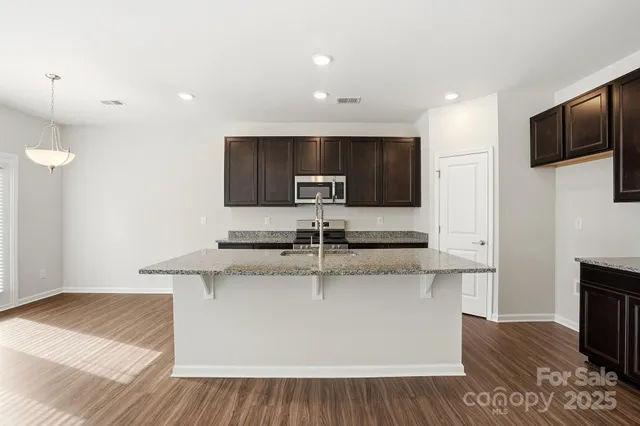 a kitchen with stainless steel appliances granite countertop a sink and a stove