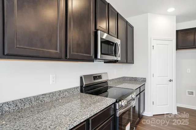 a kitchen with stainless steel appliances granite countertop a sink stove and microwave
