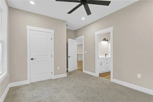 an empty room with closet and a ceiling fan