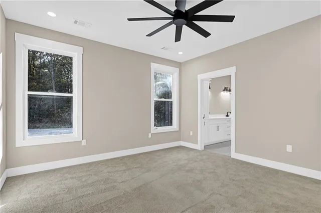 an empty room with a window and a ceiling fan