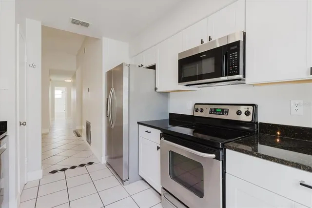 an empty room with mirror and a bathroom