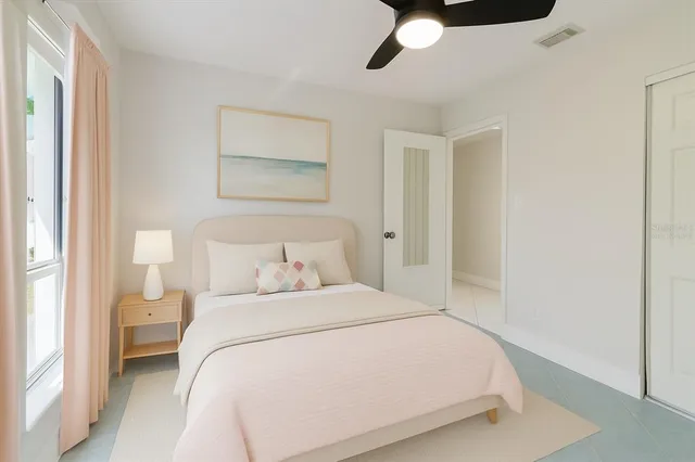 an empty room with a window and a fan