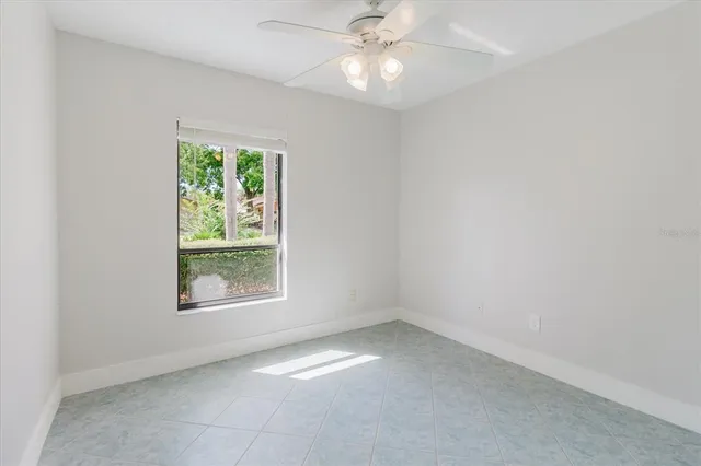 an empty room with a chandelier fan