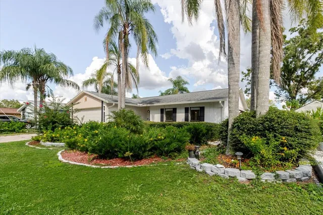 a front view of a house with a yard and potted plants