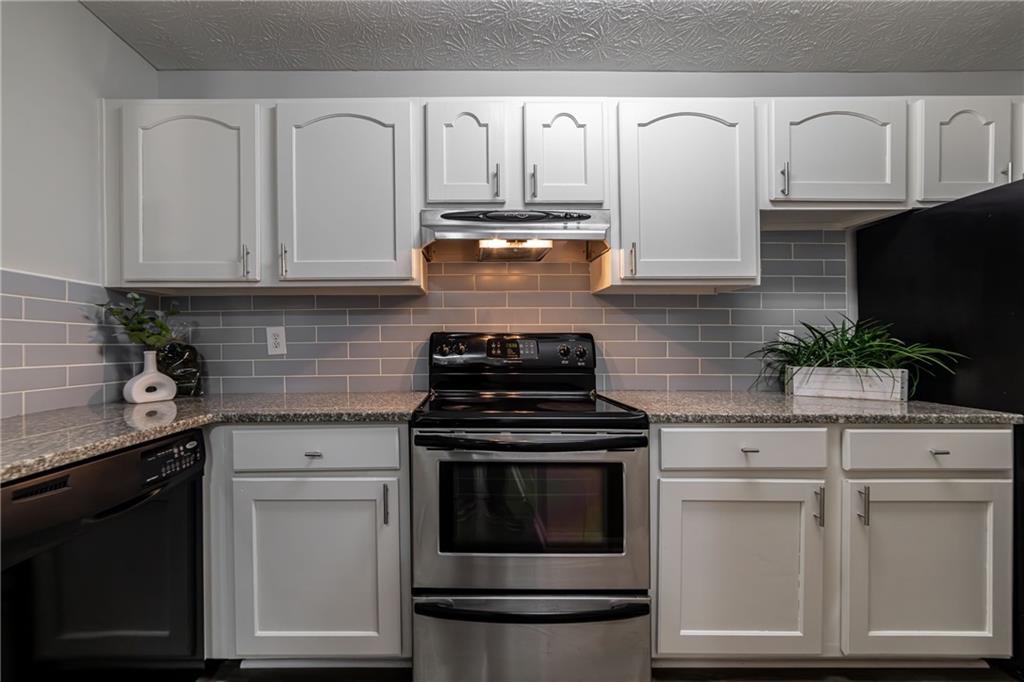 970 Sidney Marcus Boulevard Northeast, Unit 1204 Atlanta, GA 30324 - Photo 14 of 60 a kitchen with granite countertop white cabinets and black appliances
