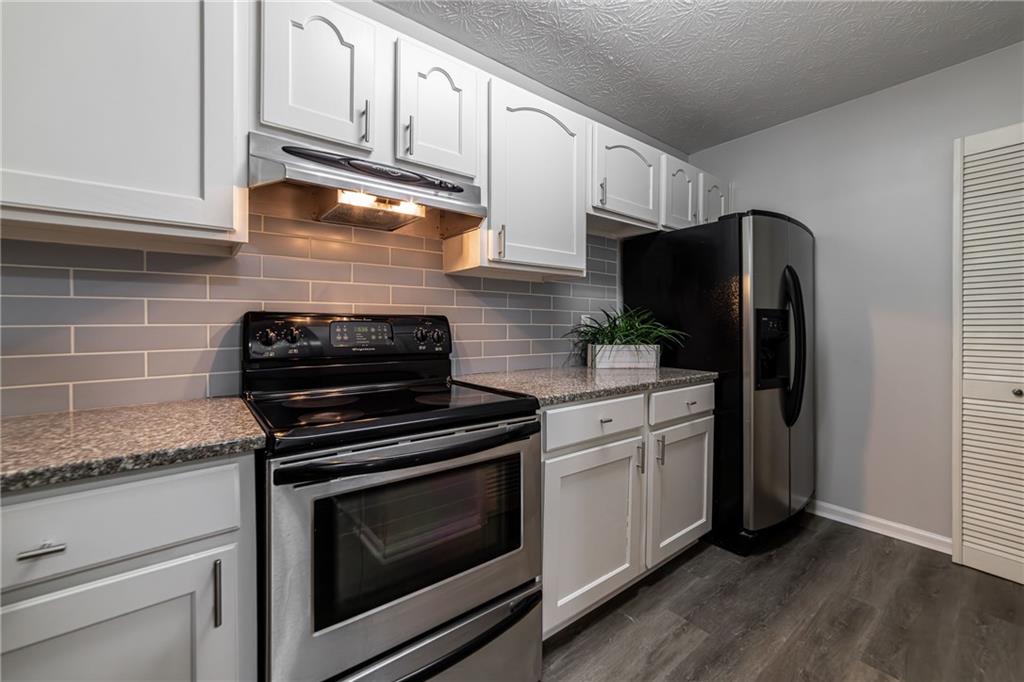 970 Sidney Marcus Boulevard Northeast, Unit 1204 Atlanta, GA 30324 - Photo 15 of 60 a kitchen with stainless steel appliances granite countertop a stove and a refrigerator