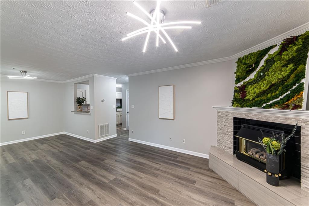 970 Sidney Marcus Boulevard Northeast, Unit 1204 Atlanta, GA 30324 - Photo 2 of 60 a view of an empty room with wooden floor fireplace and a window
