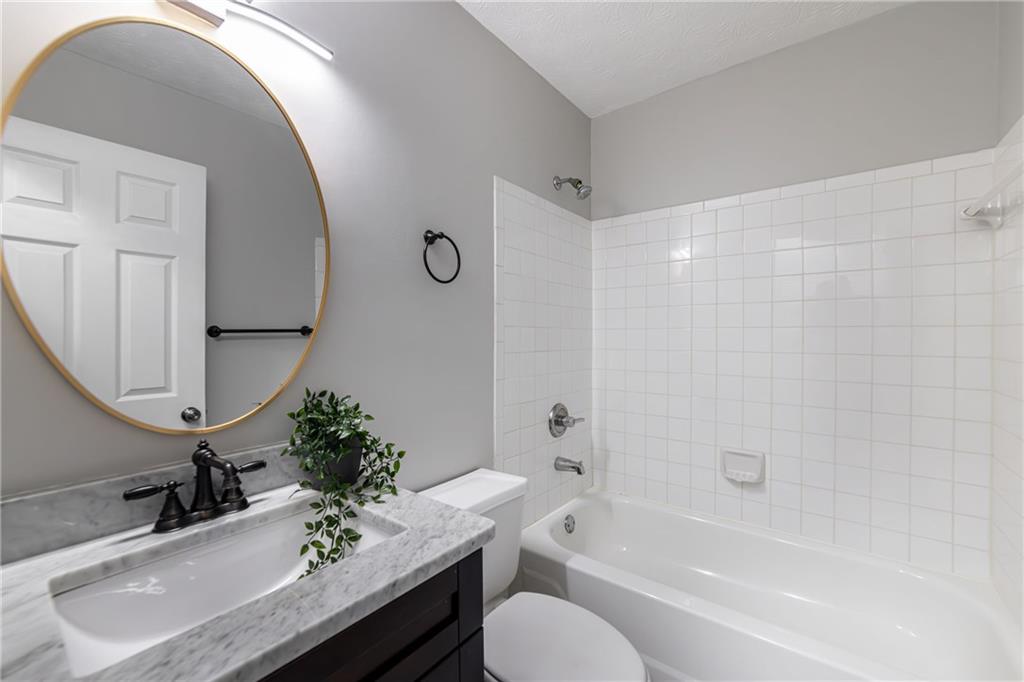 970 Sidney Marcus Boulevard Northeast, Unit 1204 Atlanta, GA 30324 - Photo 21 of 60 a bathroom with a granite countertop sink toilet and shower