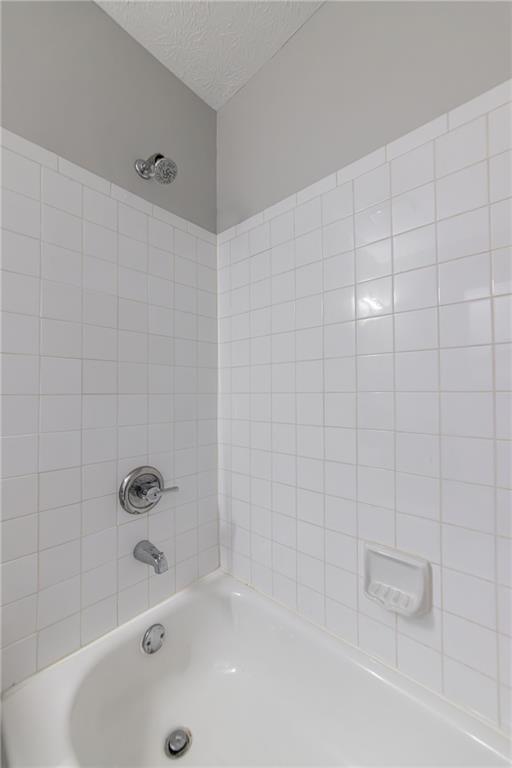 970 Sidney Marcus Boulevard Northeast, Unit 1204 Atlanta, GA 30324 - Photo 22 of 60 a bathroom with a tub and a shower
