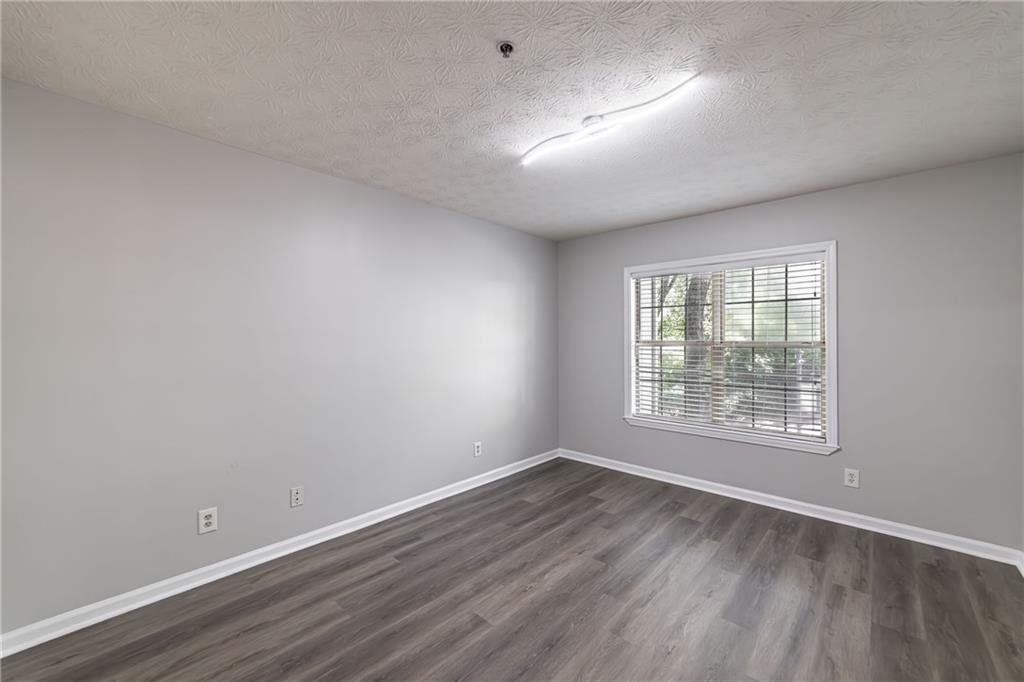 970 Sidney Marcus Boulevard Northeast, Unit 1204 Atlanta, GA 30324 - Photo 24 of 60 an empty room with wooden floor and windows
