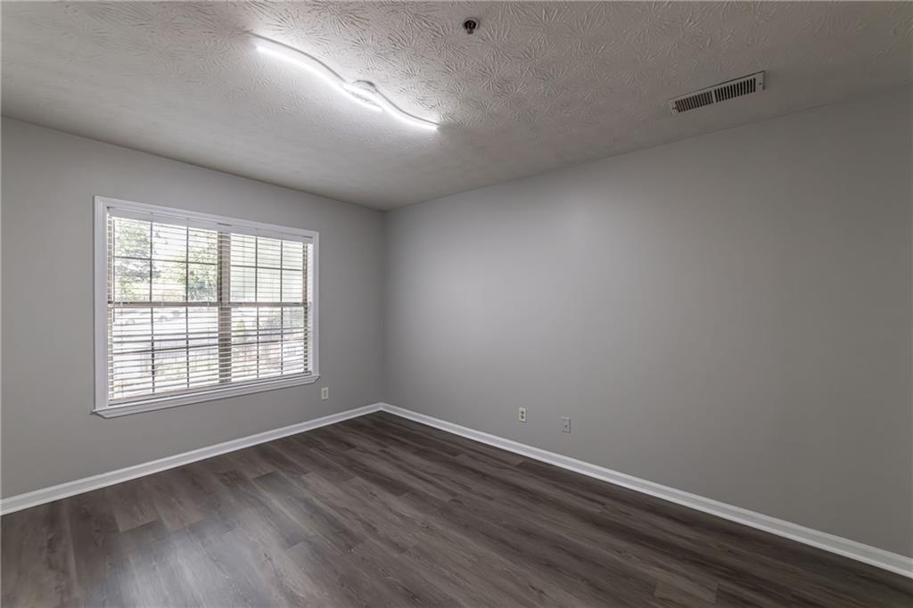 970 Sidney Marcus Boulevard Northeast, Unit 1204 Atlanta, GA 30324 - Photo 28 of 60 an empty room with wooden floor and windows