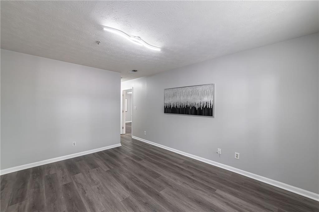 970 Sidney Marcus Boulevard Northeast, Unit 1204 Atlanta, GA 30324 - Photo 38 of 60 a view of an empty room with wooden floor and a window