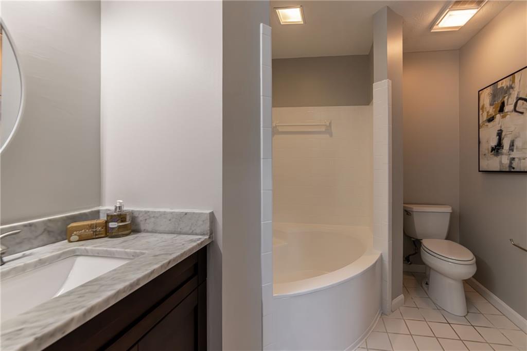970 Sidney Marcus Boulevard Northeast, Unit 1204 Atlanta, GA 30324 - Photo 44 of 60 a bathroom with a granite countertop sink a toilet and bathtub