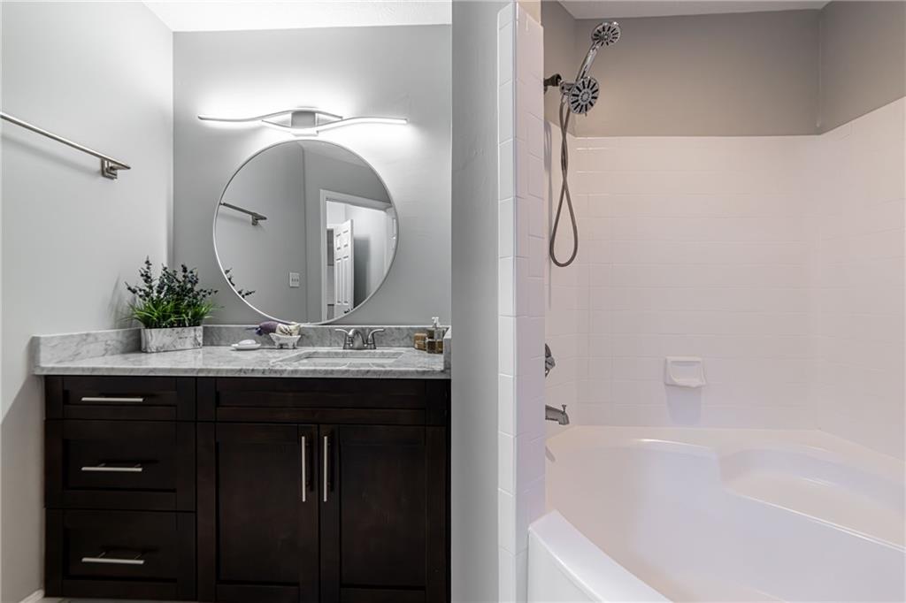 970 Sidney Marcus Boulevard Northeast, Unit 1204 Atlanta, GA 30324 - Photo 46 of 60 a bathroom with a granite countertop sink a mirror and a bathtub