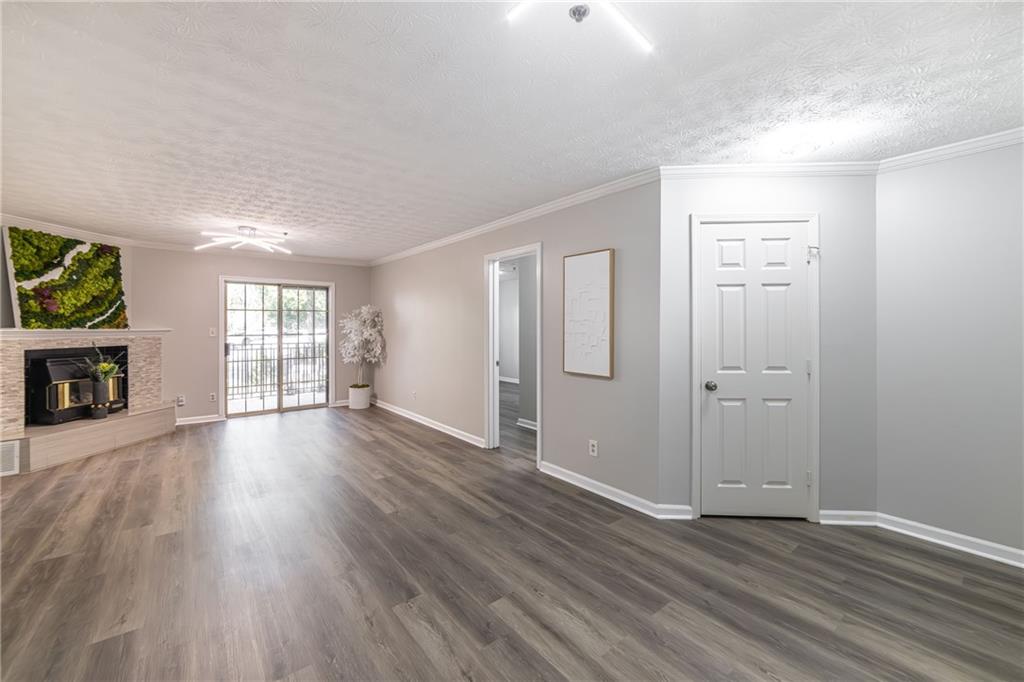 970 Sidney Marcus Boulevard Northeast, Unit 1204 Atlanta, GA 30324 - Photo 7 of 60 an empty room with wooden floor and a fireplace