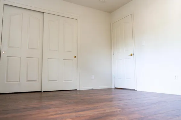 a view of an empty room with wooden floor