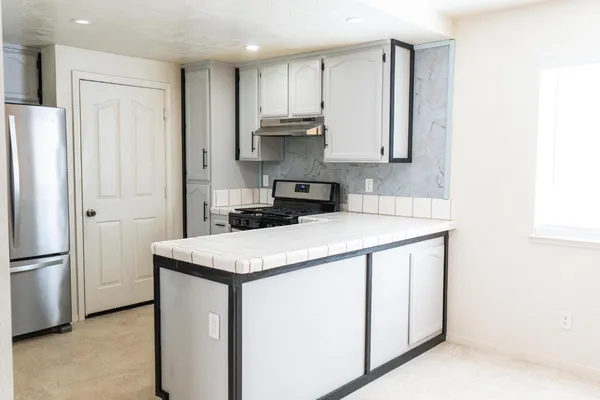 a kitchen with a refrigerator sink and cabinets