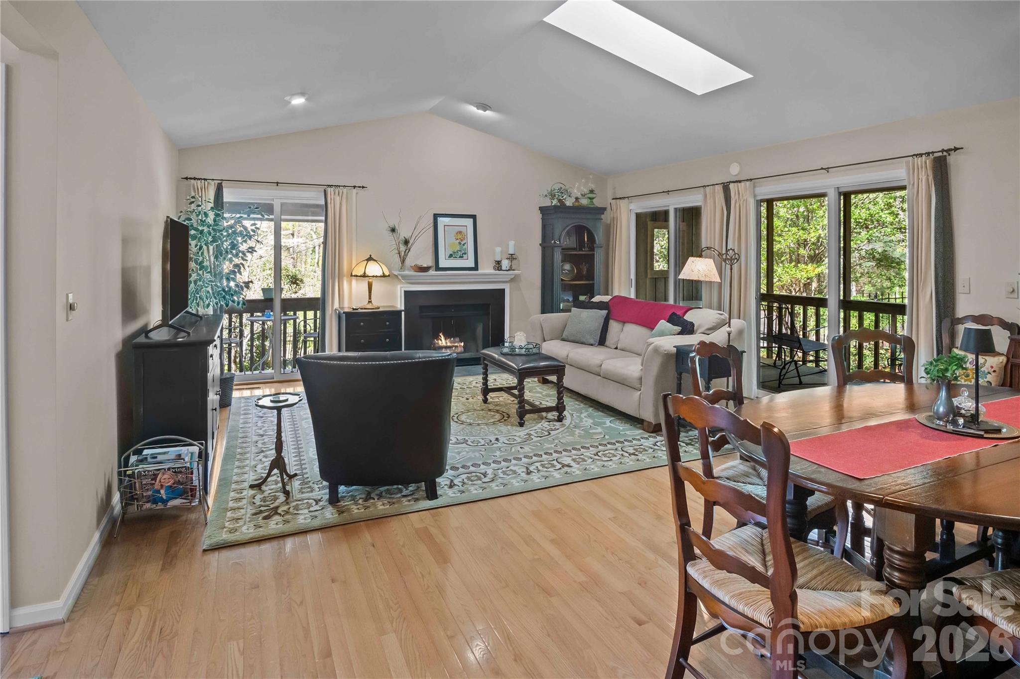 335 Melrose Avenue, Unit 103 Tryon, NC 28782 - Photo 13 of 38 a living room with furniture a flat screen tv and a floor to ceiling window
