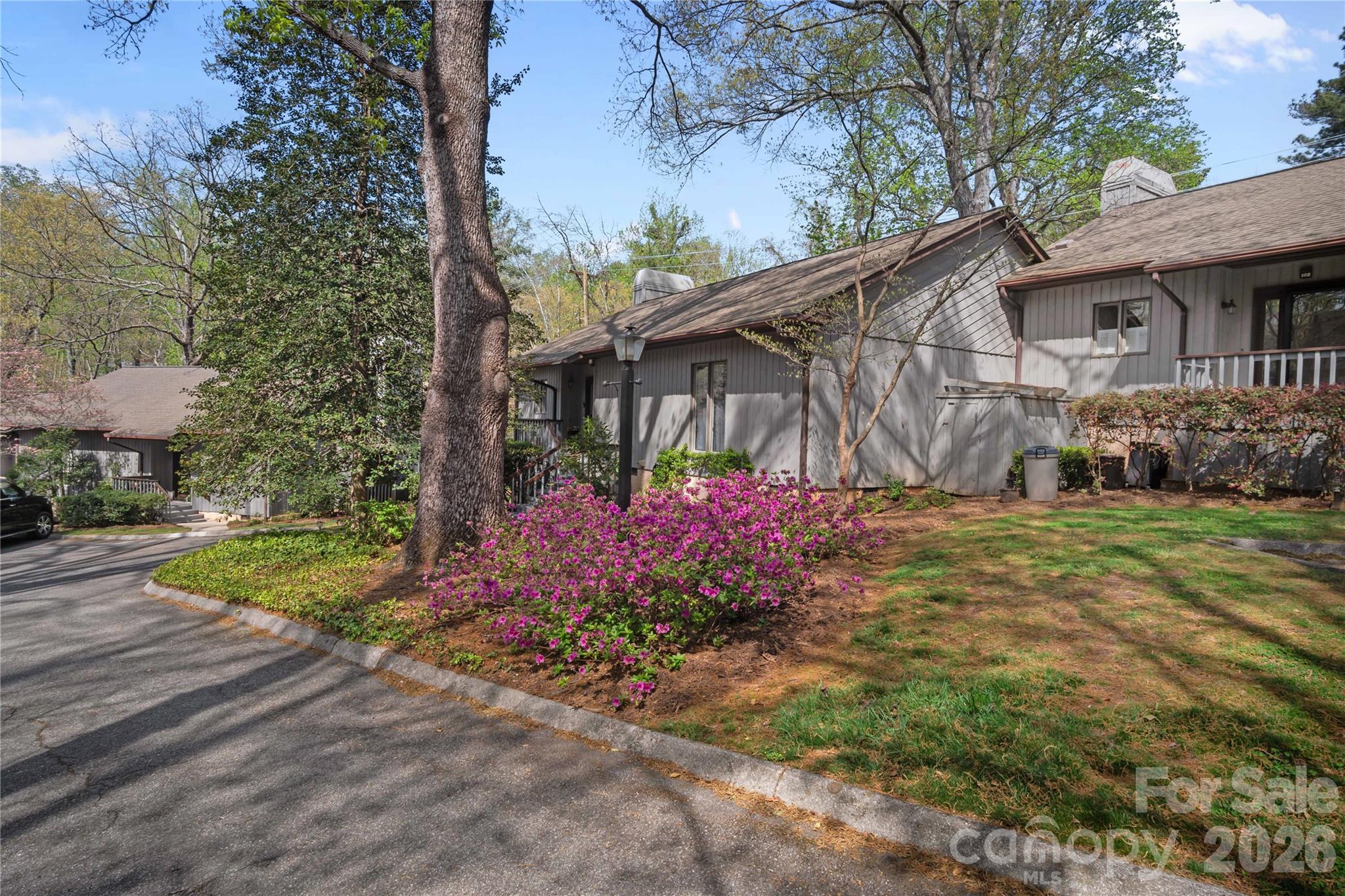 335 Melrose Avenue, Unit 103 Tryon, NC 28782 - Photo 2 of 38 a view of a white house next to a yard with a fountain